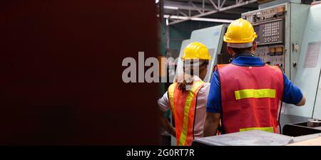 Leiter des Werksingenieurs mit gelbem Hut und Überprüfung der Maschine, jährliches Wartungskonzept Stockfoto