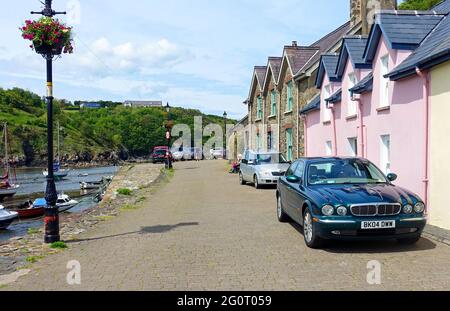 Farbenfrohe Fischerhütten am malerischen Kai des Fishguard Old Town Harbour, viele davon wurden inzwischen zu Ferienhäusern umgebaut Stockfoto