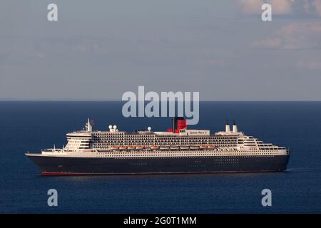 Das prächtige Queen Mary 2 Ozeandampfer-Kreuzschiff sitzt auf ruhigem Meer, während es vor Torbay in Devon, Großbritannien, vor Anker liegt. Stockfoto