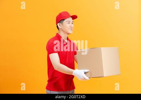 Freundlicher, lächelnder Kurier, der den Kunden ein Paket gab und dem Kunden einen Karton überreichte Stockfoto