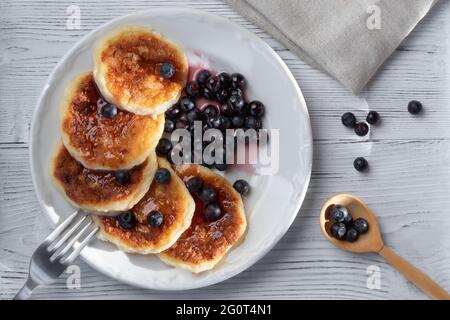 Frische Hüttenpfannkuchen mit Käse und Heidelbeeren in Sirup. Sommerfrühstück im Dorf. Top Aussicht Stockfoto