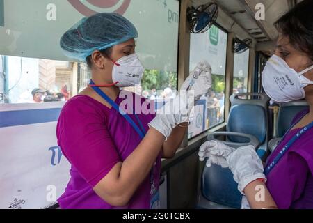 Kalkutta, Indien. Juni 2021. Ein Mitarbeiter des Gesundheitswesens bereitet in Kalkutta eine Dosis des Covid-19-Impfstoffes bei der „Radimpfung“ vor. Ein Bus wurde in ein COVID-Impfzentrum umgewandelt, um den Anstieg der COVID-19-Fälle in Indien einzudämmen. (Foto von Dipayan Bose/SOPA Images/Sipa USA) Quelle: SIPA USA/Alamy Live News Stockfoto