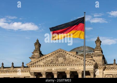 Deutsche Flagge vor dem Deutschen Bundestag - Reichstagsgebäude - Berlin, Deutschland - Text sagt: Dem deutschen Volk Stockfoto