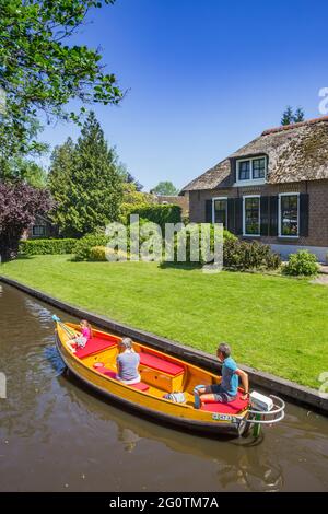 Farbenfrohes elektrisches Motorboot im historischen Kanal von Giethoorn, Niederlande Stockfoto