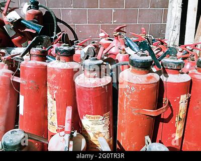 Alte sowjetische russische Feuerlöschgeräte werden für die Entsorgung im Müll in der Fabrik im Freien vorbereitet Stockfoto