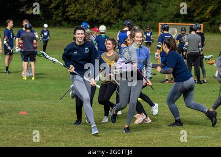 Frischere Studentinnen an der University of East Anglia, die Lacrosse ausprobieren Stockfoto