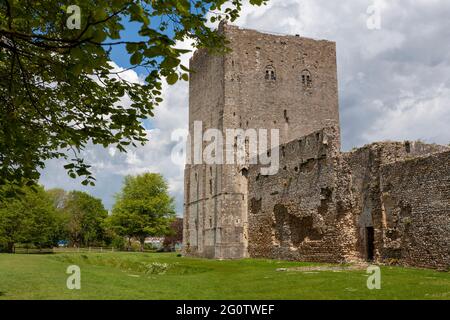 Der normannische Bergfried von Portchester Castle und ein Teil der ursprünglichen römischen Festungsmauern, Portchester, Hampshire, Großbritannien Stockfoto