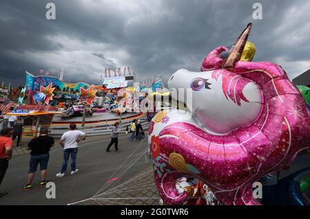 Lingen, Deutschland. Juni 2021. Vor einem Karussell ist im mobilen Freizeitpark 'LinGoFun' ein Folienballon in Form eines Einhorns zu sehen. 47 Schausteller laden vom 3. Bis 27. Juni 2021 auf dem Gelände neben den Emslandhallen unter Berücksichtigung der Corona-Verhaltensregeln zu ihren Fahrgeschäften und Attraktionen ein. Quelle: Friso Gentsch/dpa/Alamy Live News Stockfoto