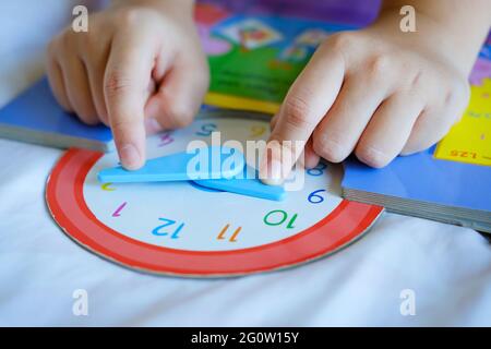 Kind spielen sagen Zeit Spiel, kleine Kinder zu lernen, wie man eine analoge Uhr zu lesen. Stockfoto