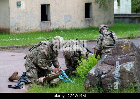 Baumholder, Deutschland. Juni 2021. US-Soldaten kümmern sich während einer Übung um eine Soldatinnen mit einer Schusswunde. Im Rahmen der US-geführten Militärübung 'Defender Europe 21' trainierten Truppen im Militärausbildungsgebiet Baumholder unter anderem den Transport und die Betreuung von Verwundeten. Quelle: Harald Tittel/dpa/Alamy Live News Stockfoto