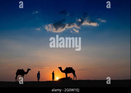 Silhouette von zwei Kamelen und ihre Kamele an den Sanddünen der Thar-Wüste, Rajasthan, Indien. Wolke mit untergehenden Sonne, Himmel im Hintergrund. Kameraleuten Stockfoto