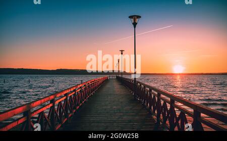Anlegestelle am Strand im Sommer in Polen bei Sonnenuntergang aus Sicht des Vanishing Point. Farbenfrohe Entspannung am Ufer während eines Spaziergangs. Stockfoto