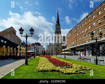 NOVI SAD, SERBIEN - 25. April 2012: Novi Sad, Serbien, 25. April 2012.:Zentrum der Stadt, Blick auf die Kirche des Namens Mariens und Frühlingsblumen. Pla Stockfoto