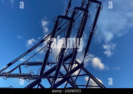 Industrieleiter im Stromnetz eines Hochspannungsnetzes an der Hochspannungsleitung. Silhouettenaufnahme von Leistungsleitern. Stockfoto