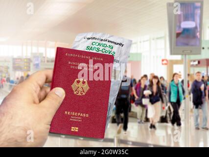 Hand mit einem deutschen Pass und einem faltigen Coronavirus Covid 19-Immunitätszertifikat aus Papier. Verschwommener Flughafen im Hintergrund. Immunität gegen Covi Stockfoto