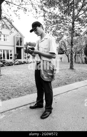 JOHANNESBURG, SÜDAFRIKA - 05. Jan 2021: Johannesburg, Südafrika - 11. September 2010: Post Mailman Hand liefert Post in einem wohlhabenden Vorort Stockfoto