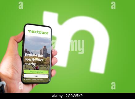 San Francisco, CA, USA, Mai 2021: Der nebenan gelegene Startbildschirm der Anwendung auf einem handgeführten Smartphone-Bildschirm. Nebenan Logo verschwommen auf dem Hintergrund. Nex Stockfoto