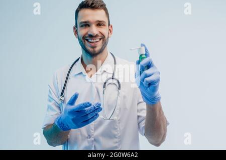 Lächelnder männlicher Arzt zeigt Inhalator im Studio Stockfoto