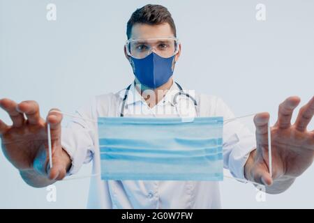 Europäischer Arzt mit medizinischer Maske in den Händen Stockfoto