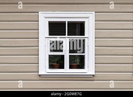 Fenster mit weißem Holzrahmen in einer beigefarbenen Wand Stockfoto