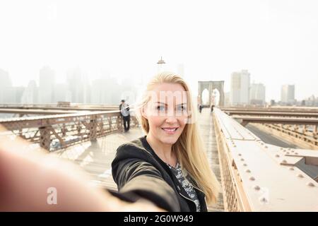 Lächelnde Frau beim Selfie auf der städtischen Stadtbrücke Stockfoto