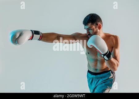 Fokussierter junger bärtiger europäischer Boxer boxt Stockfoto