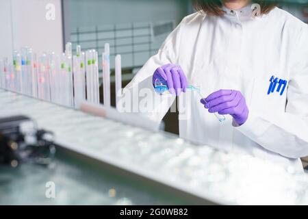 Forscher hält einen Kolben mit Chemikalien und Reagenzien in seinem Hände Stockfoto