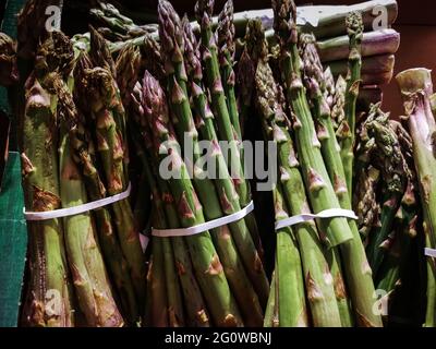 Bündeln von grünem Spargel auf dem Markt, Nahaufnahme, Draufsicht Stockfoto