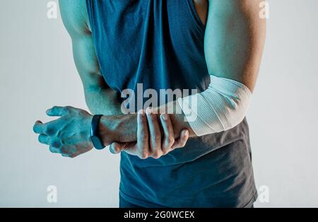 Der Sportler hält seine verletzte Hand im Studio Stockfoto