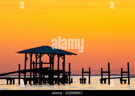 Die Sonne geht hinter einem Pier unter, der durch den US-amerikanischen Unfallheer Zeta in der Mobile Bay beschädigt wurde, wie am 4. November 2020 aus Fairhope, AL, USA, zu sehen war. Stockfoto