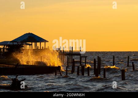 Am 29. Oktober 2020 brechen Wellen gegen einen Pier in Fairhope, Alabama, USA, bei Sonnenuntergang. Stockfoto