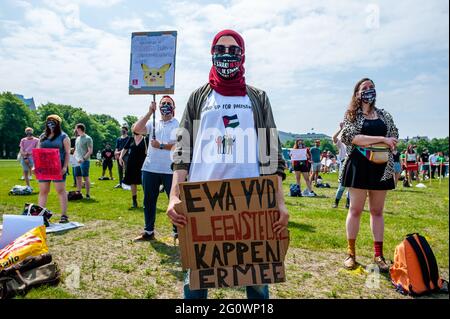 Ein Student in einem Hijab trägt ein pro Palestine T-Shirt, während er während der Demonstration ein Plakat hält.Studentensyndikate LSVb (Landelijke Studentenvakbond, was National Student Union bedeutet) und FNV (Federatie Nederlandse Vakbeweging Meaning Federation of Dutch Trade Unions) Young and United organisierte einen landesweiten Studentenstreik im Malieveld in Den Haag, wo sich Tausende von Studenten versammelten, um ein Ende des Kreditsystems, ein schuldenfreies Grundgeld und eine Entschädigung für alle Jahre, die sie sich leihen mussten, zu fordern. Stockfoto