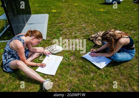 Den Haag, Niederlande. Juni 2021. Während der Demonstration werden zwei Studentinnen gesehen, die Botschaften auf Plakaten schreiben.Studentenverbände LSVb (Landelijke Studentenvakbond, was die nationale Studentenvereinigung bedeutet) und FNV (Federatie Nederlandse Vakbeweging, was die Föderation der niederländischen Gewerkschaften bedeutet) Young and United organisierte einen landesweiten Studentenstreik im Malieveld in Den Haag, wo sich Tausende von Studenten versammelten, um ein Ende des Kreditsystems, ein schuldenfreies Grundgeld und eine Entschädigung für alle Jahre, die sie sich leihen mussten, zu fordern. Kredit: SOPA Images Limited/Alamy Live Nachrichten Stockfoto