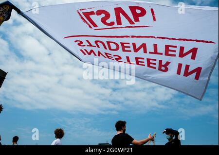 Den Haag, Niederlande. Juni 2021. Studenten werden während der Demonstration hinter einer Flagge eines Studentenverbands reden sehen.Studentenverbänden LSVb (Landelijke Studentenvakbond bedeutet nationale Studentenvereinigung) und FNV (Federatie Nederlandse Vakbeweging Bedeutung Federation of Dutch Trade Unions) Young and United organisierte einen landesweiten Studentenstreik im Malieveld in Den Haag, wo sich Tausende von Studenten versammelten, um ein Ende des Kreditsystems, ein schuldenfreies Grundgeld und eine Entschädigung für alle Jahre, die sie sich leihen mussten, zu fordern. Kredit: SOPA Images Limited/Alamy Live Nachrichten Stockfoto