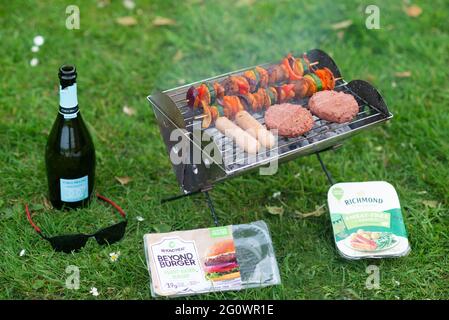 Ein veganer Grill auf pflanzlicher Basis mit Beyond Meat Burgern, fleischfreien richmond-Würstchen und Gemüsekebabs mit dem, was die Hühnerstücke anstecken. Stockfoto