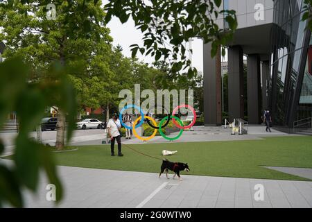 Shinjuku, Japan. Juni 2021. Ein Mann, der 50 Tage vor den Olympischen und Paralympischen Spielen in Tokio mit seinem Hund an den Olympischen Ringen im Japanischen Olympischen Museum vorbeiläuft. (Foto: Jinhee Lee/SOPA Images/Sipa USA) Quelle: SIPA USA/Alamy Live News Stockfoto