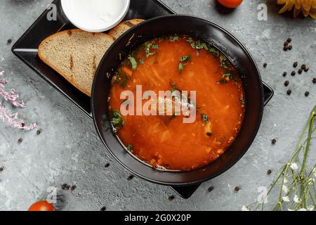 Traditionelles ukrainisches russisches Borscht mit weißen Bohnen auf der schwarzen Schale. Flach liegend. Draufsicht Stockfoto