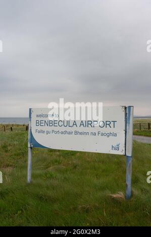 Schild für Willkommen am Flughafen Benbecula mit Hintergrund von Gras und Meer am Horizont. Speicherplatz kopieren. Keine Personen. Wolkiger Tag. Stockfoto