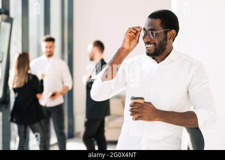 Porträt eines afroamerikanischen männlichen Büroarbeiters vor seinen Kollegen Stockfoto