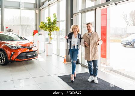 Junge schöne Paar tritt in Autohaus Stockfoto