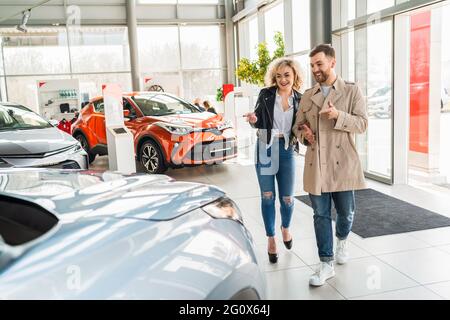 Schönes Paar im Autohaus wählt Auto Stockfoto