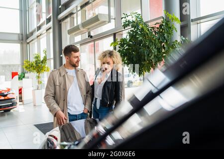 Schönes Paar im Autohaus wählt Auto Stockfoto