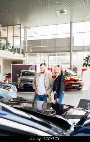 Schönes Paar im Autohaus wählt Auto Stockfoto