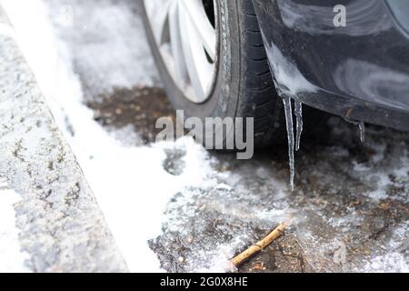 Lange Eiszapfen, die an einem Auto hängen Stockfoto