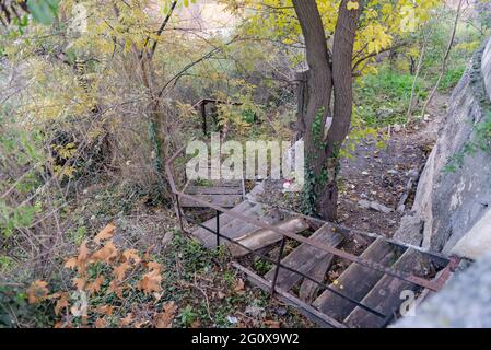 Zerstörte hölzerne Treppe in Sewastopol. Eine alte Treppe in einem der Parks, die noch nicht verbessert wurde. Eine Treppe, die in ein Dickicht führt Stockfoto