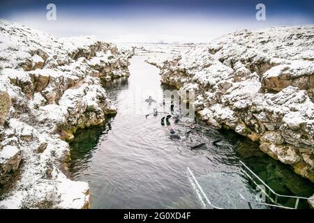 Silfra, Island-19. Feb 2020: Schnorchler bereiten sich auf das Eindringen in das Wasser am Silfra Rift vor, dem Ort, an dem sich eurasische und die amerikanische tektonische Platte befinden Stockfoto