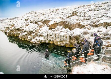 Silfra, Island-19. Feb 2020: Schnorchler bereiten sich auf das Eindringen in das Wasser am Silfra Rift vor, dem Ort, an dem sich eurasische und die amerikanische tektonische Platte befinden Stockfoto