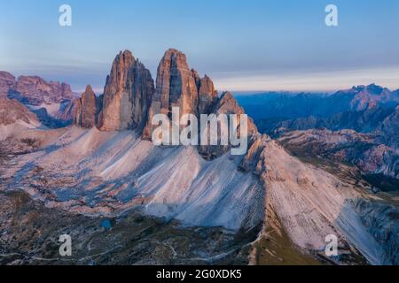 Luftaufnahme der Gipfel der Tre Cime bei rosa Sonnenuntergangslicht, Dolomiten Alpen. Nationalpark, Italien. Stockfoto