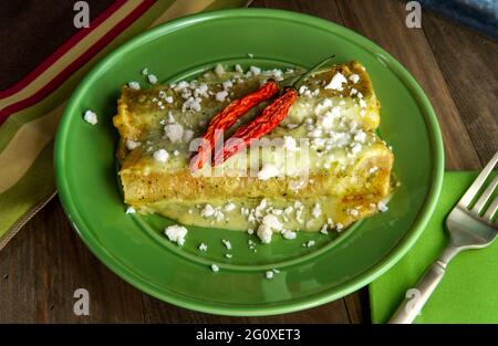 Mexikanische Enchiladas mit cremiger Poblano-Pfeffer-Sauce und Queso Fresco-Käse Stockfoto
