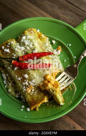 Mexikanische Enchiladas mit cremiger Poblano-Pfeffer-Sauce und Queso Fresco-Käse Stockfoto